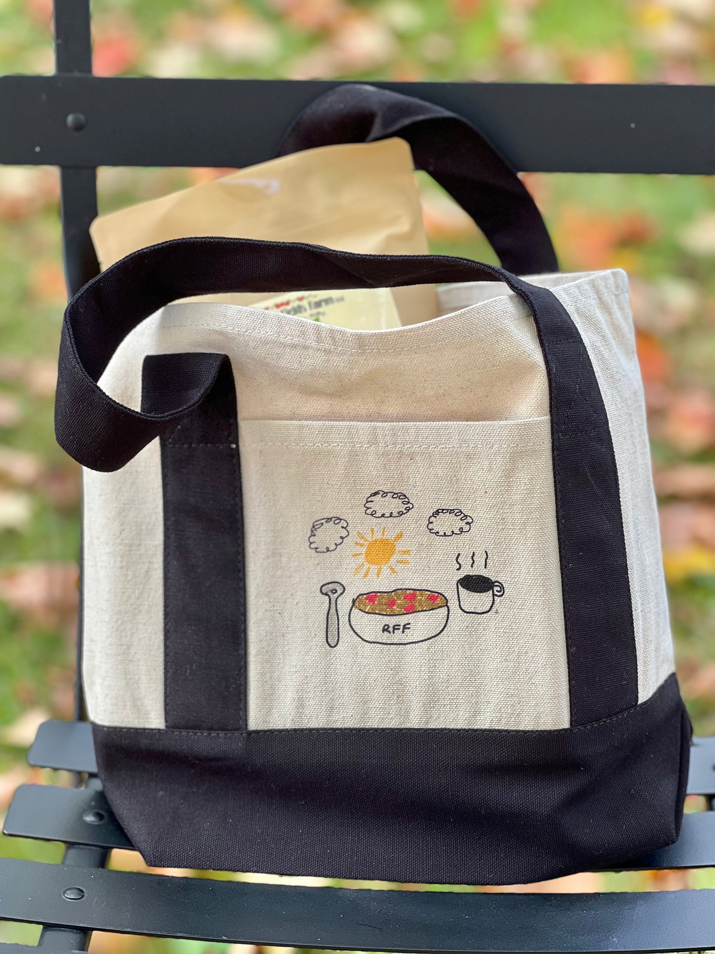 Tote bag with food illustrations on a black chair outdoors