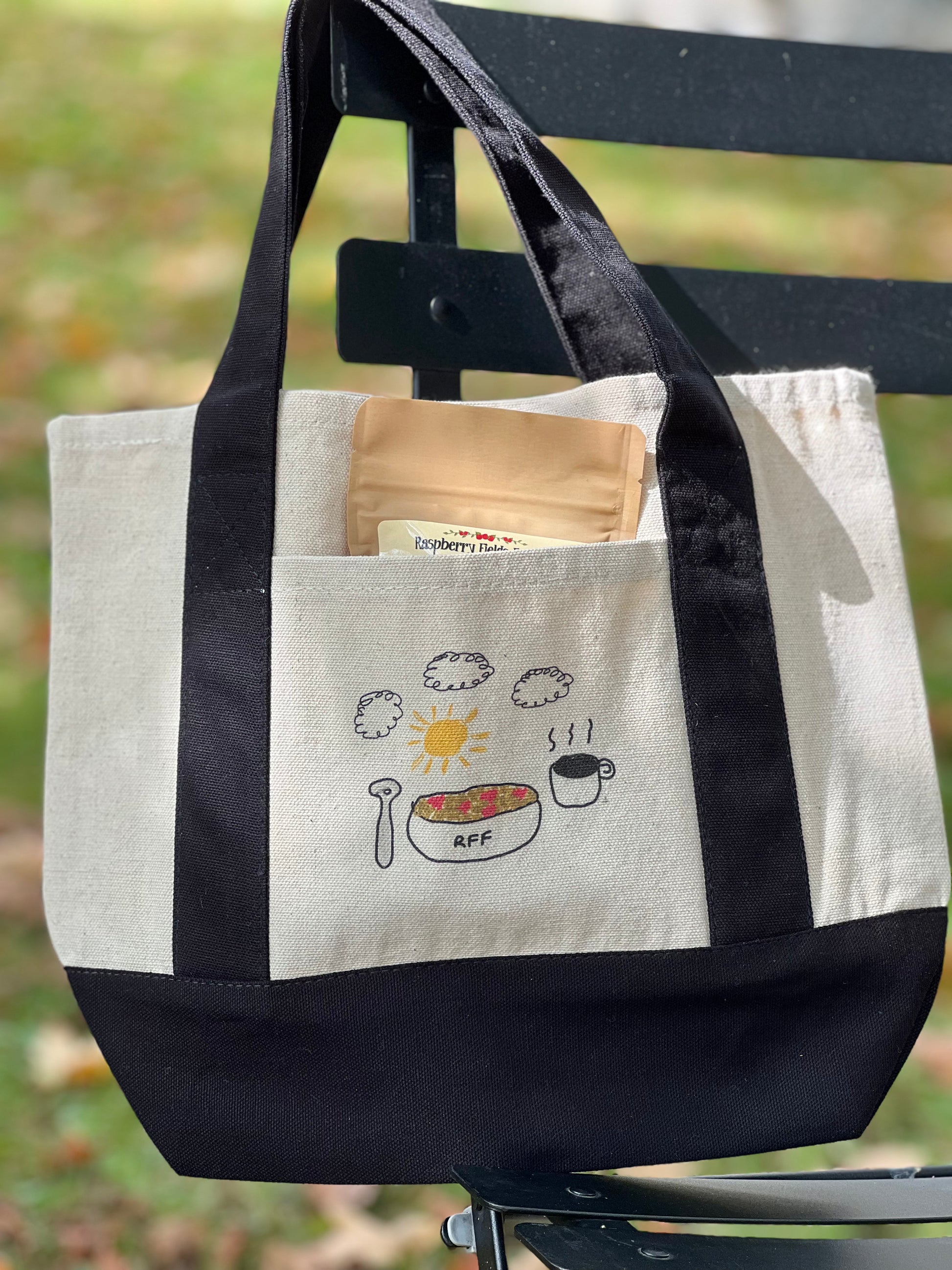 Tote bag with black handles on a bench outdoors